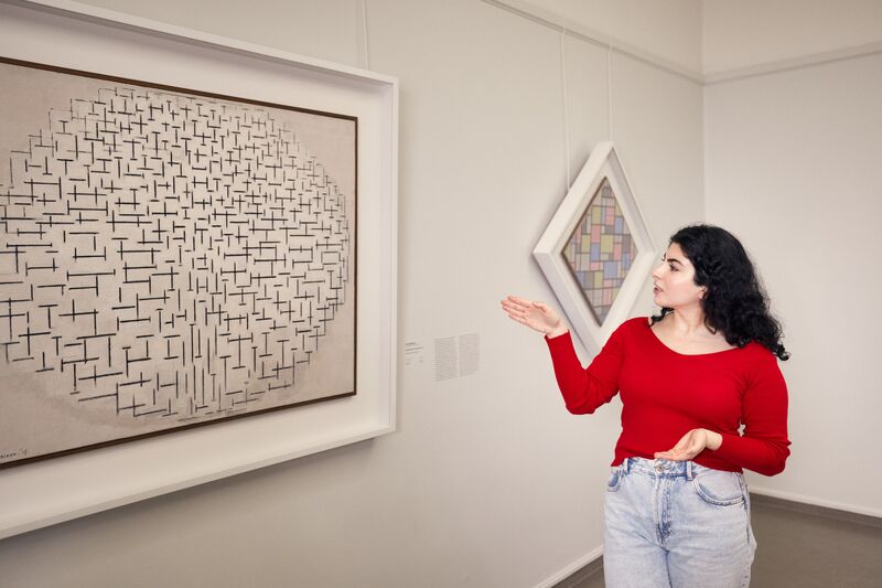 Bezoeker bij een schilderij van Piet Mondriaan