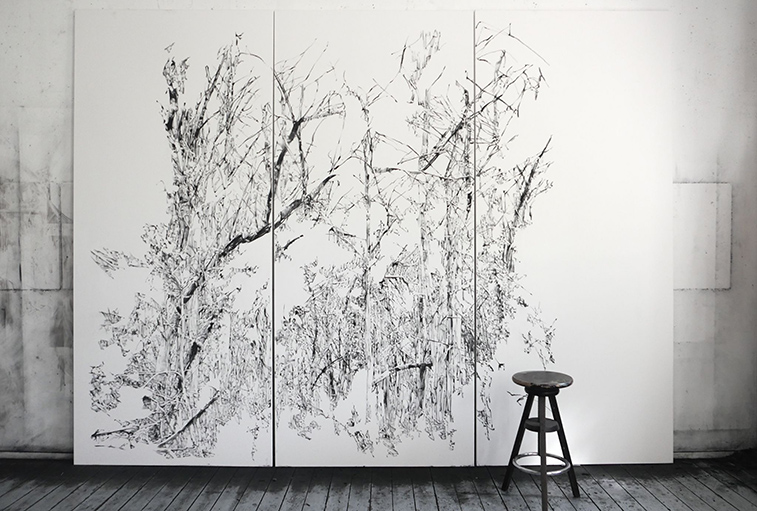 atelierfoto met een grote wandvullende houtskooltekening van Anouk Griffioen, met een krukje ervoor