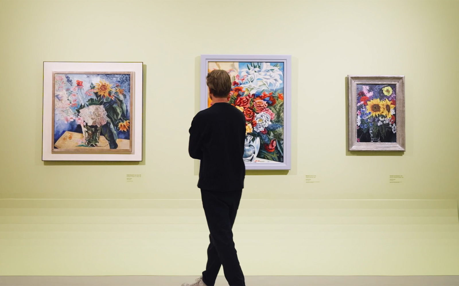 bezoeker voor drie schilderijen van Charley Toorop